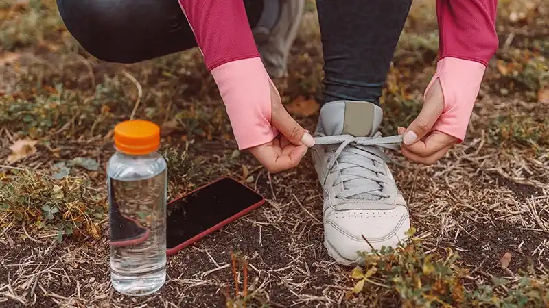 getting started woman ties shoes before jogging