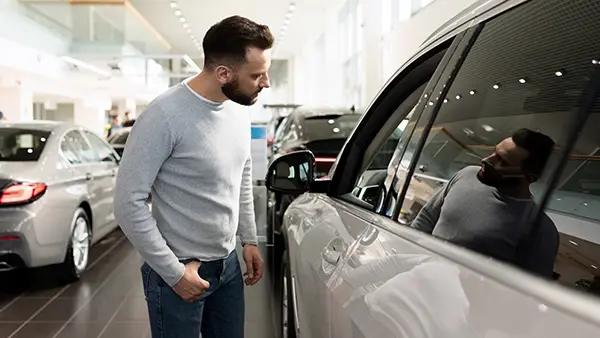 car dealer seo attract more traffic man examining vehicles in showroom