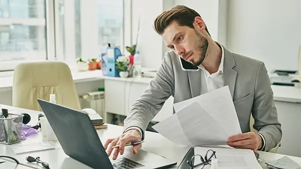 financial services busy young office worker online and on phone